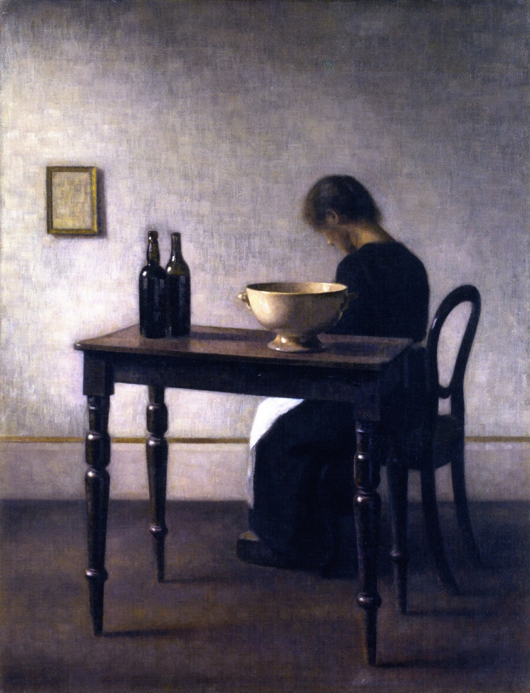 Interior with a woman sitting at the table and a ceramic bowl