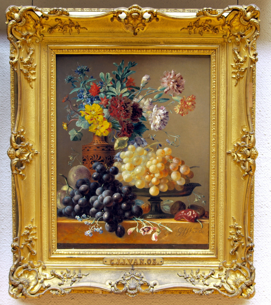 Bodegón con frutas y flores en un jarrón griego.